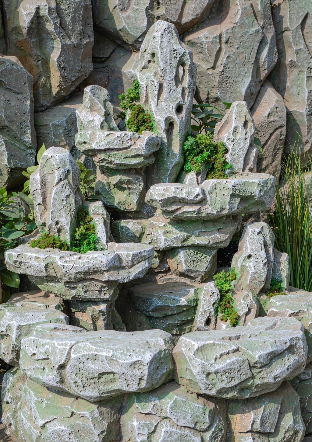 Artificial rockery feature with waterfall planting detail in a resort spa garden