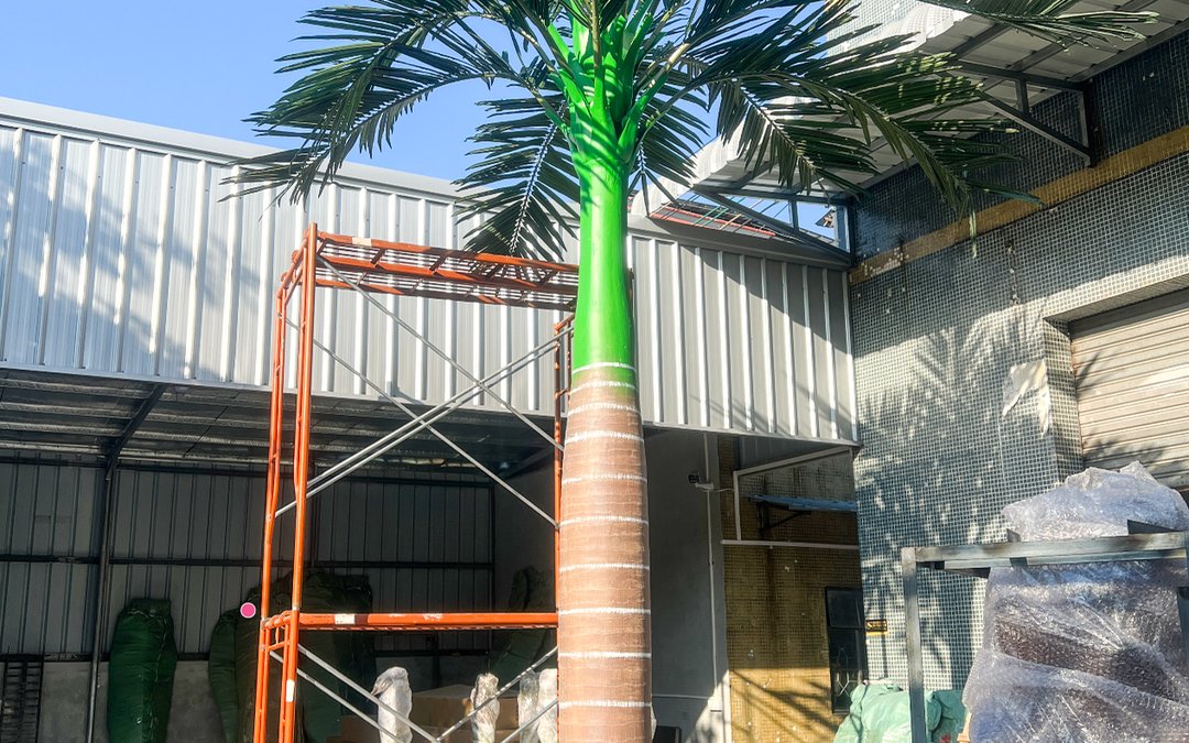 Palm raised beside a scaffold frame at the factory gate
