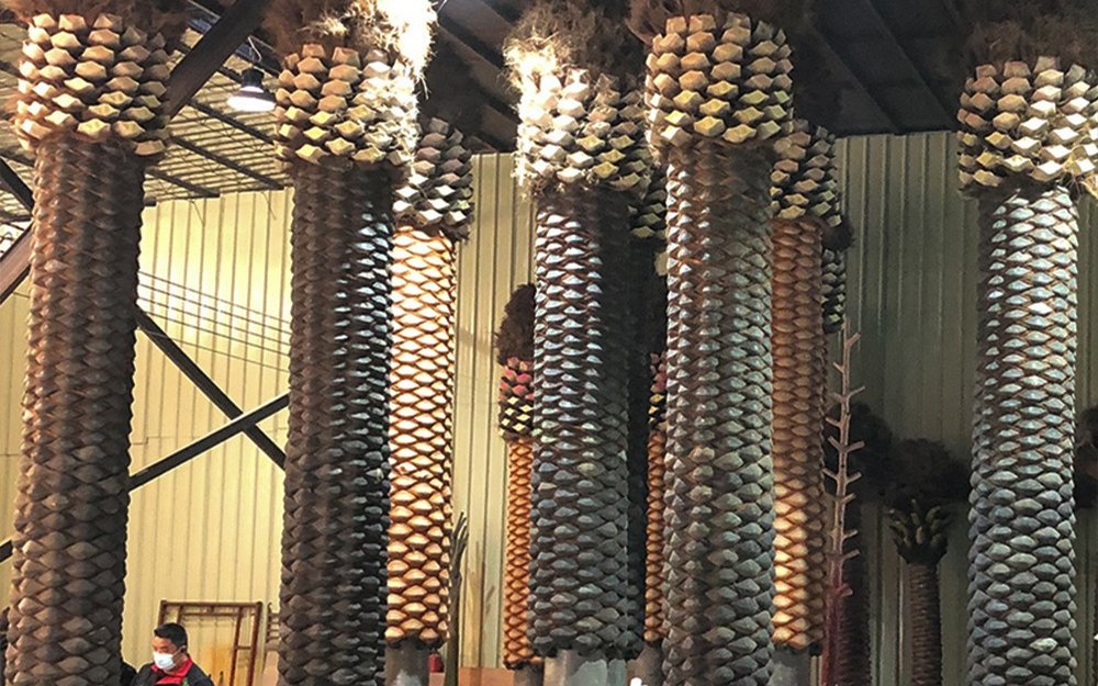 Moulded artificial palm trunks standing in rows inside the production workshop