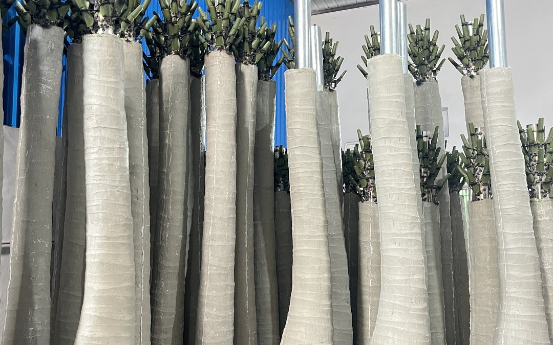 Rows of moulded trunk shells with steel cores and leaf sockets exposed