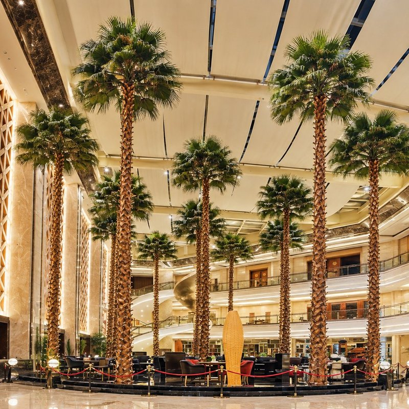 Artificial palm trees in a marble hotel lobby palm court in Dubai