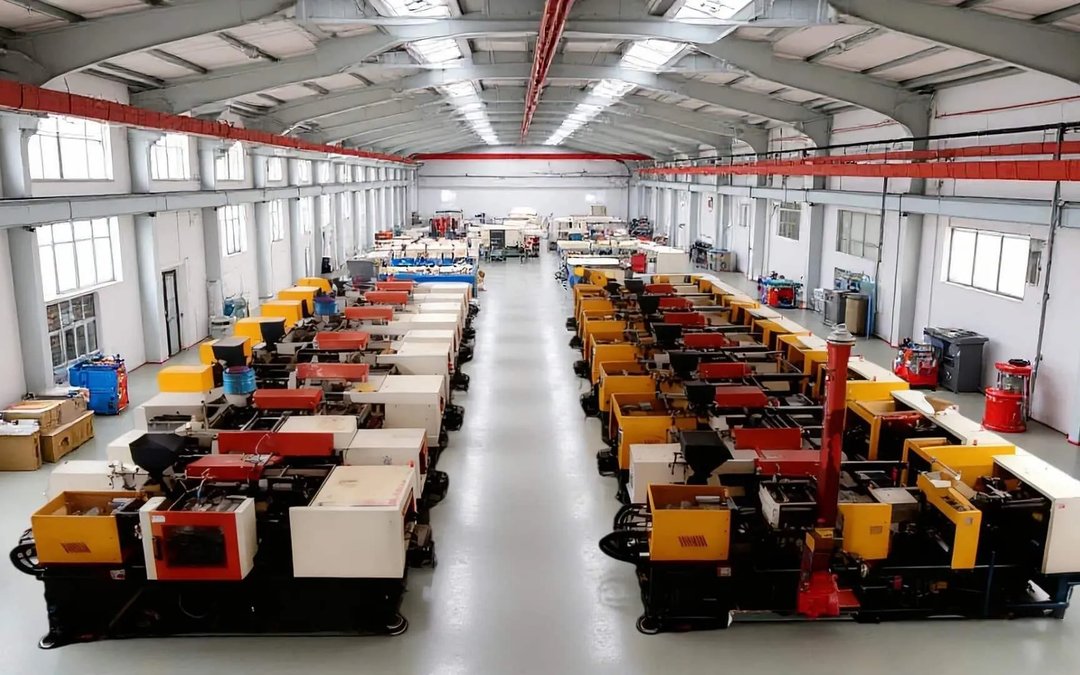 Two rows of injection-moulding machines in a clear-span factory hall