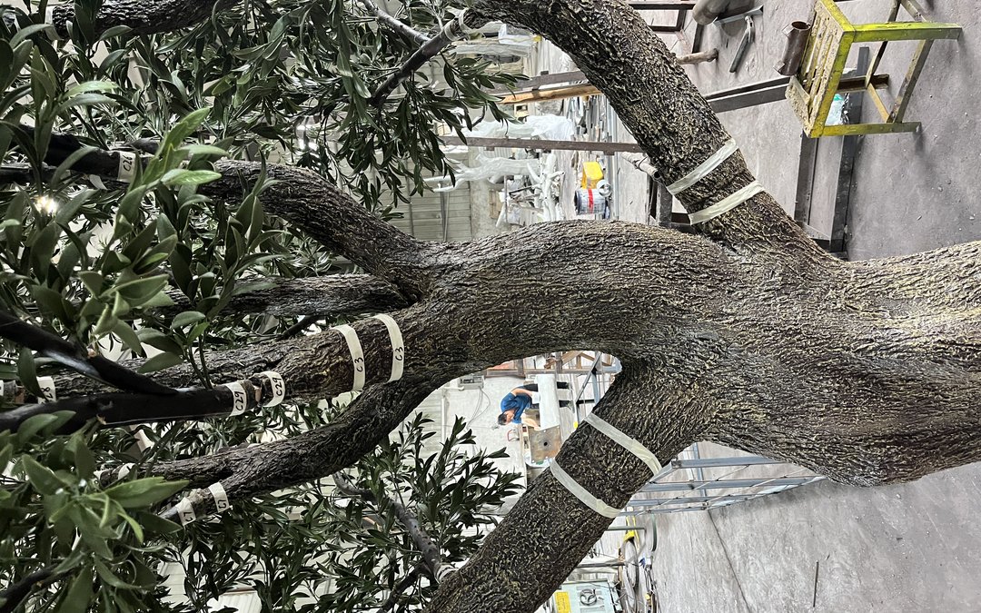 Branches of a large artificial tree wrapped with white numbered identification tags in the workshop