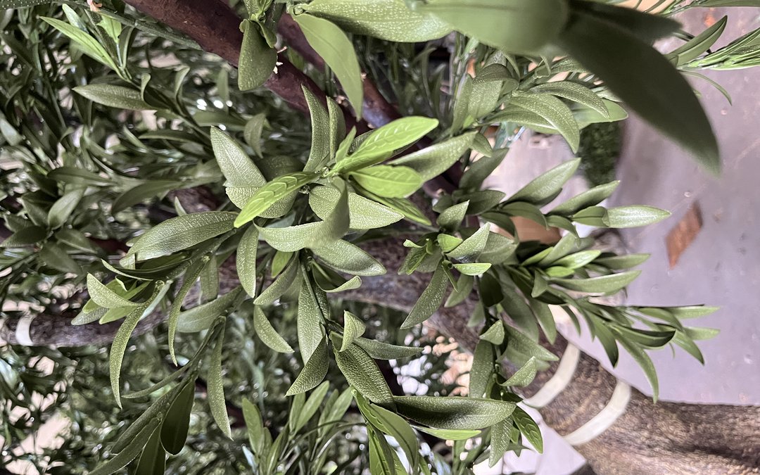 Close view of injection-moulded foliage with visible leaf veins and branch structure