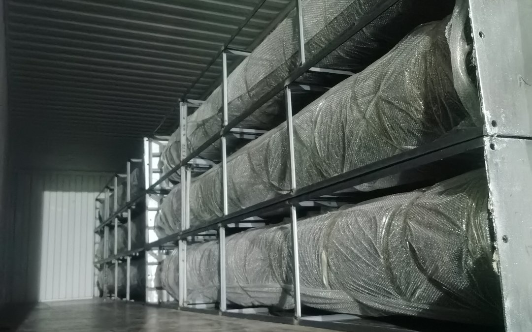 Wrapped trunk bundles and steel racks inside the container after loading