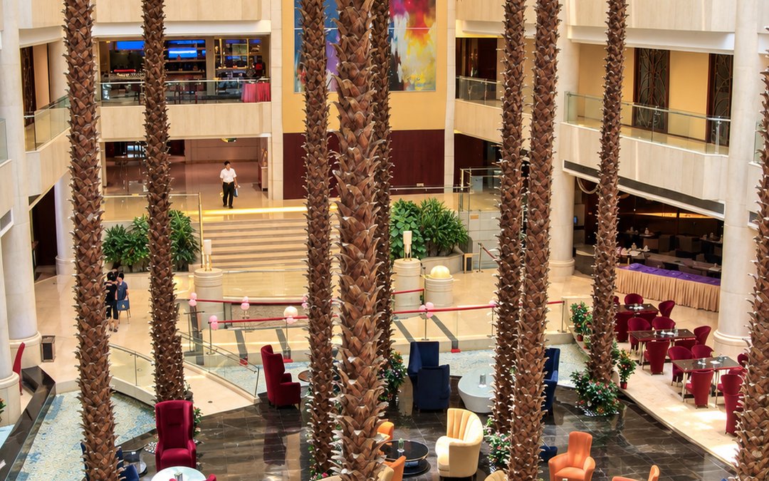Tall palms installed in a hotel atrium lounge