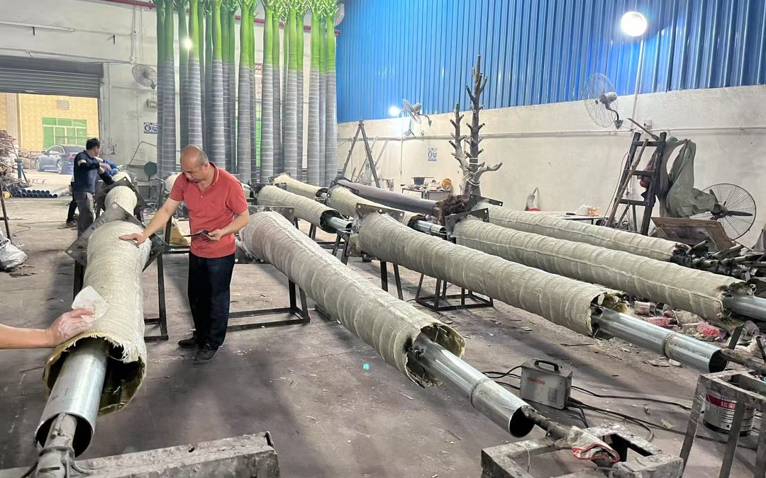 Palm trunk shells being laminated over steel cores on trestles in a workshop