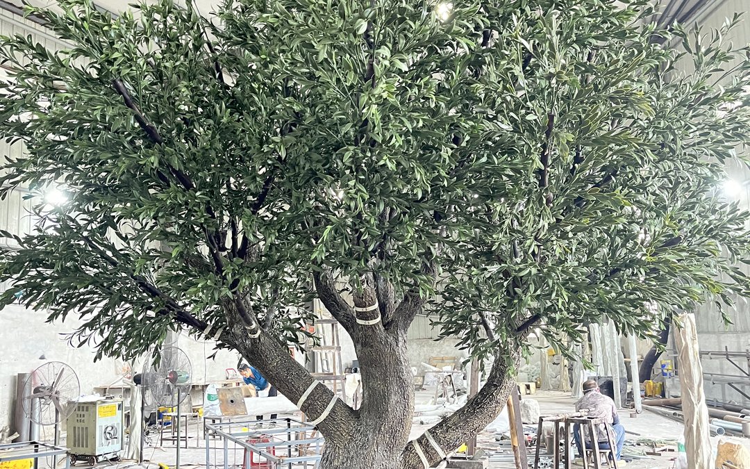 Large artificial tree standing in the workshop during assembly with the trunk banded