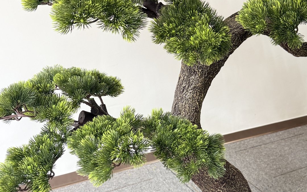 Artificial pine specimen with layered needle pads photographed indoors
