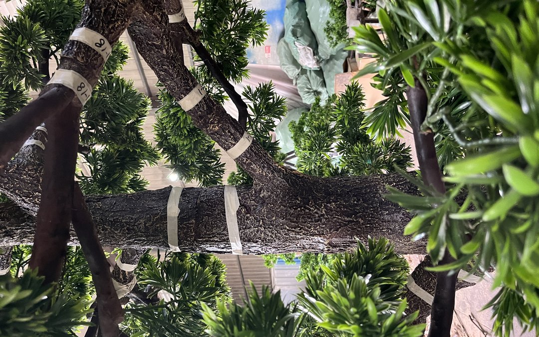 Branch ends coded with hand-written labels on a large artificial tree trunk