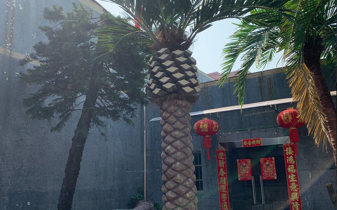 Moulded palm trunks standing at a factory gate