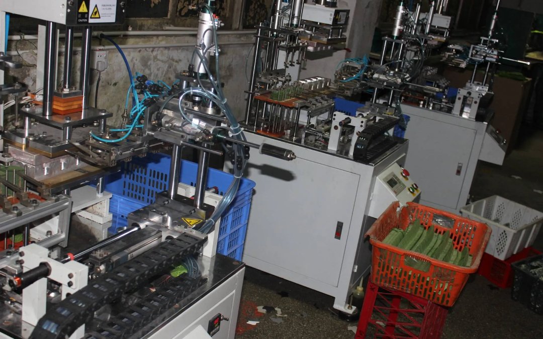 Rows of leaf injection presses with a basket of moulded green leaves in the foreground