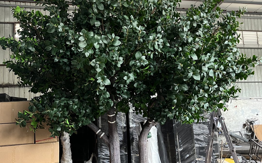 Assembled artificial ficus tree in the workshop with a banded trunk and packed cartons alongside
