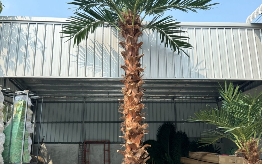 Finished date palm with moulded trunk bark standing in the factory yard