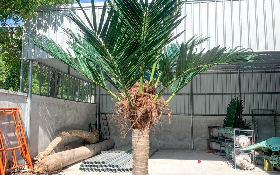 Bare-trunk date palm mock-up in the workshop yard with galvanized tube stock