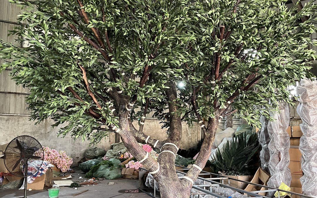 Multi-trunk artificial tree on the workshop floor with banded branch collars