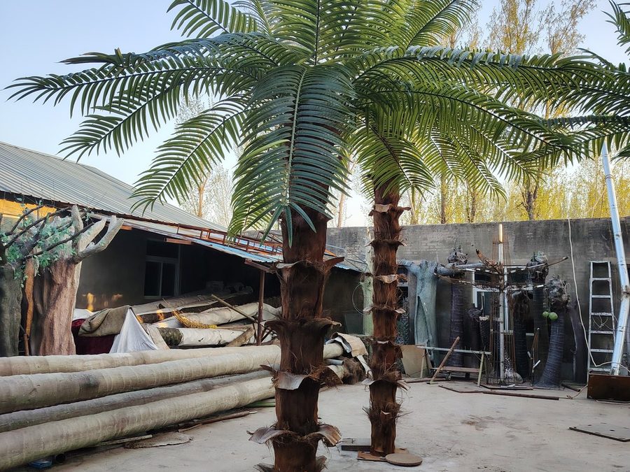 Finished artificial palm trees standing in the factory yard before final inspection