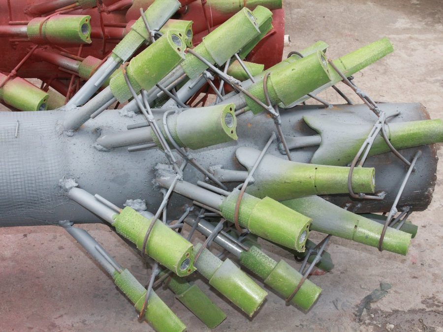 Branch mounts assembled on the galvanized steel core of an artificial palm tree