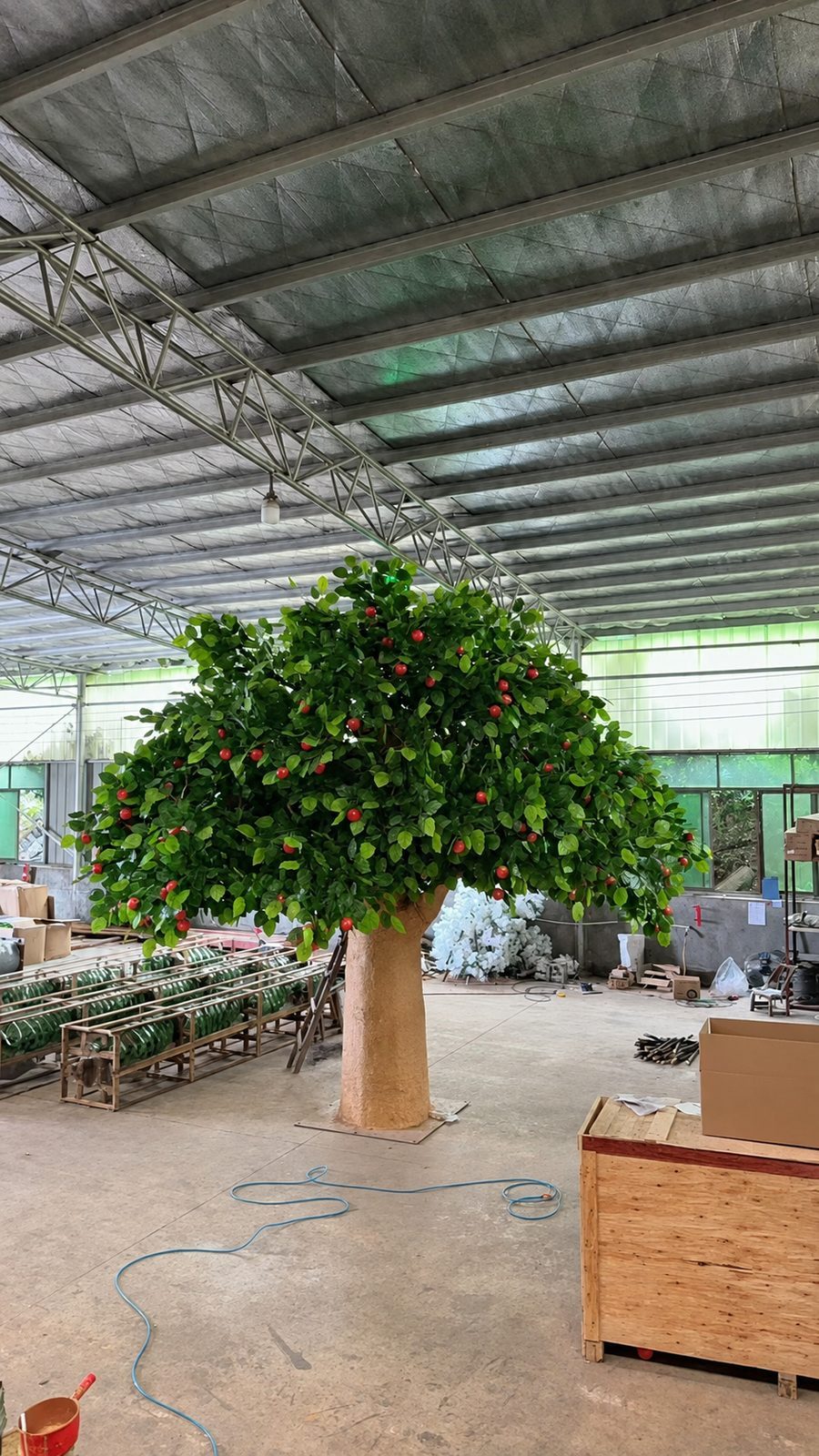 Tall artificial cherry tree with a clear trunk and fruit high in the canopy