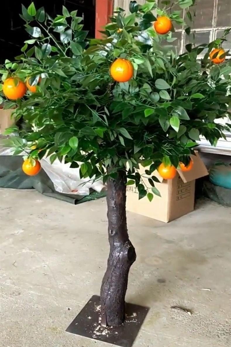 Small artificial citrus tree with oversized fruit standing in our factory