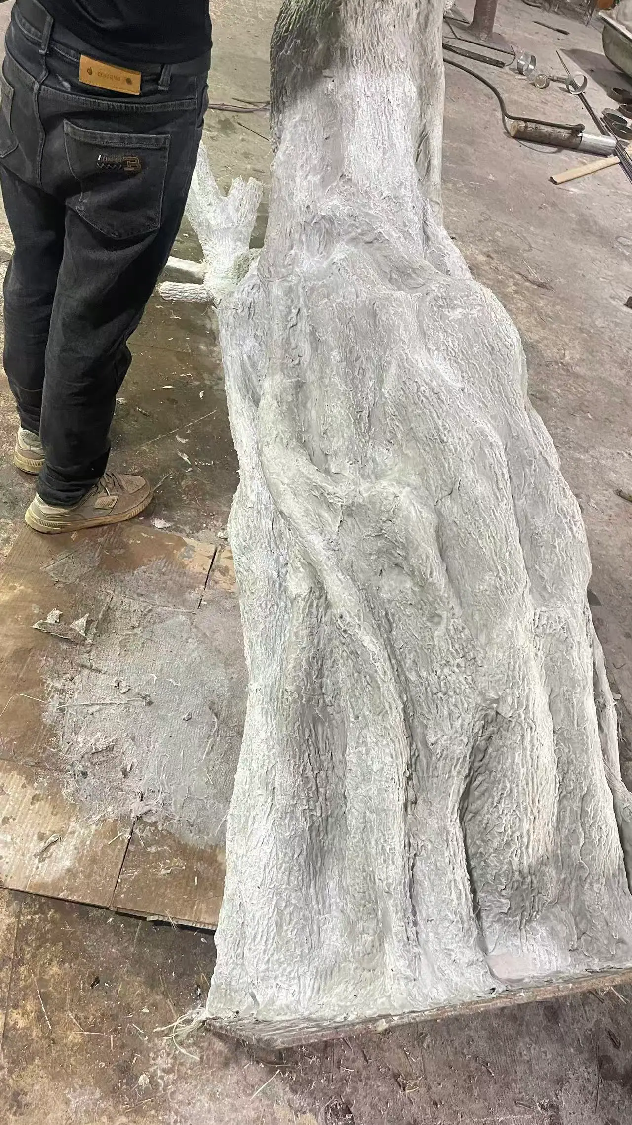 Hand carving in progress on an olive trunk